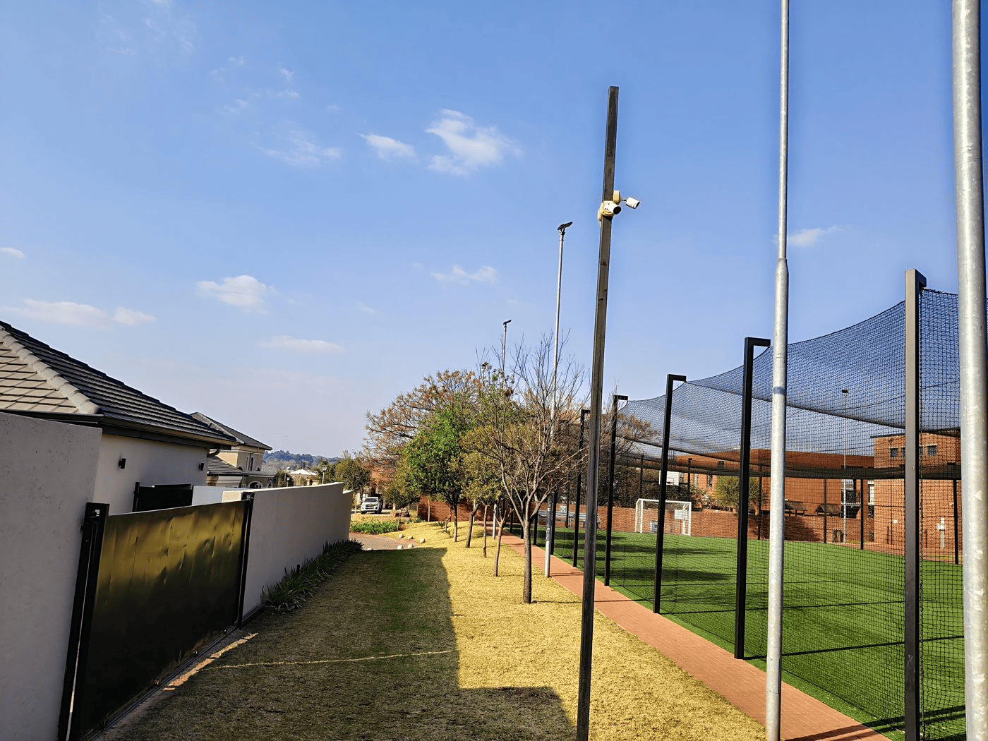 RealMe P4 Power 5G camera sample showing fencing in the foreground and distant buildings, with detail retained in the shadows